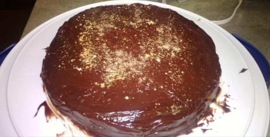 round chocolate glazed cake on a white tray