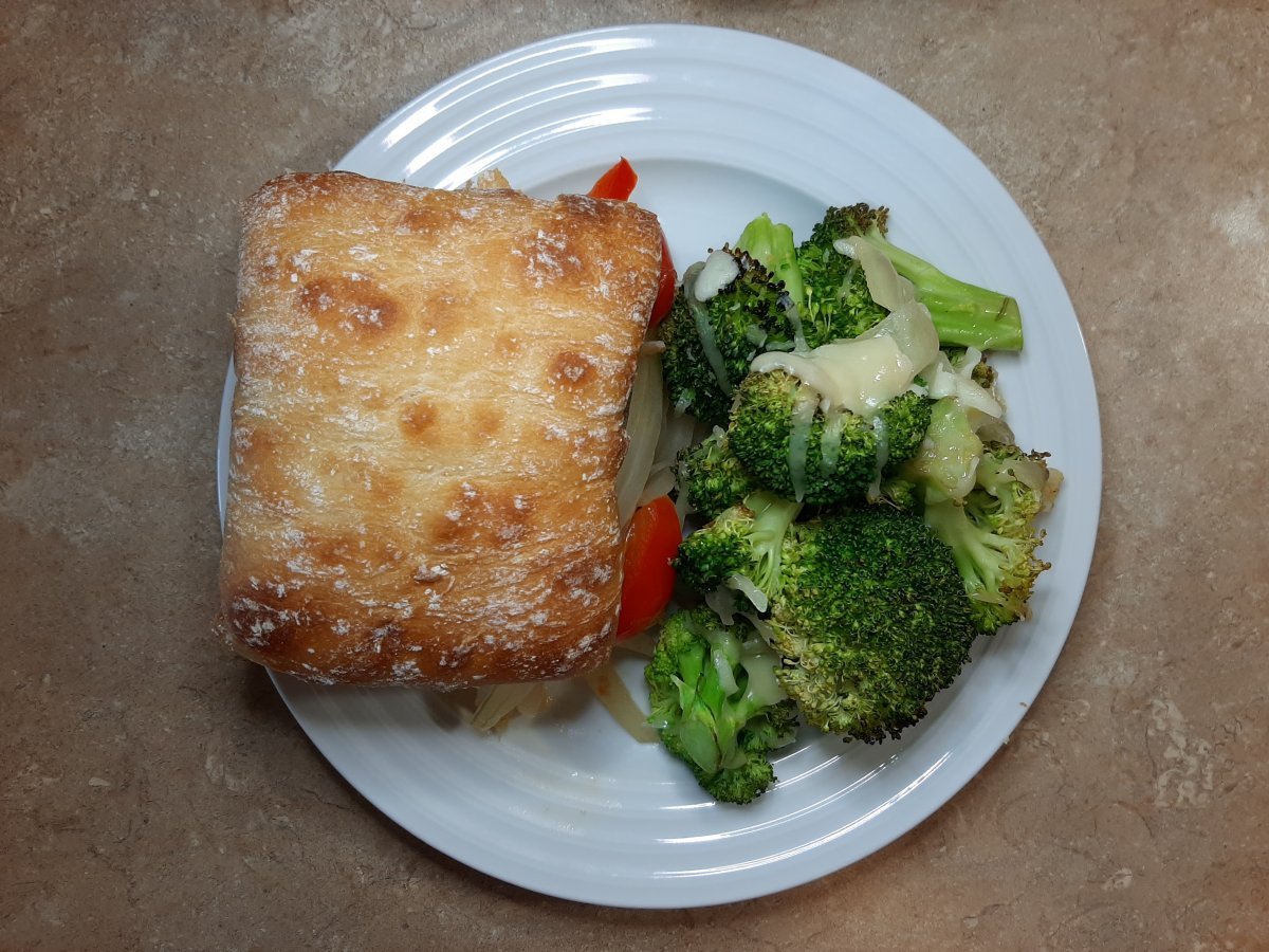 Italian sausage sandwich with a side of oven roasted broccoli with cheese